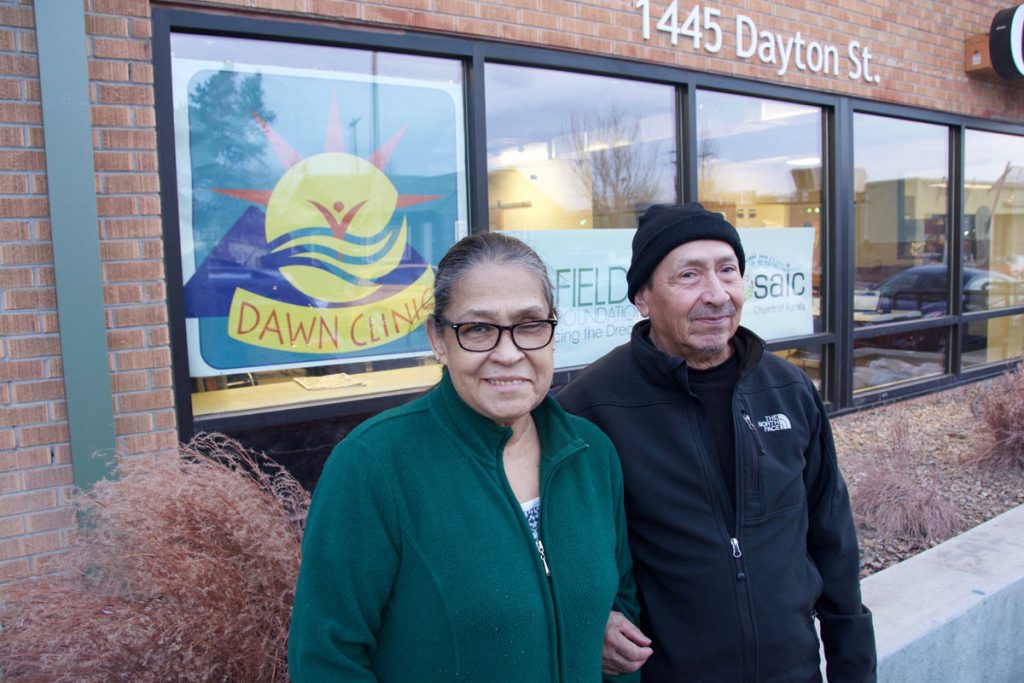 a couple poses outside the DAWN Clinic in Aurora