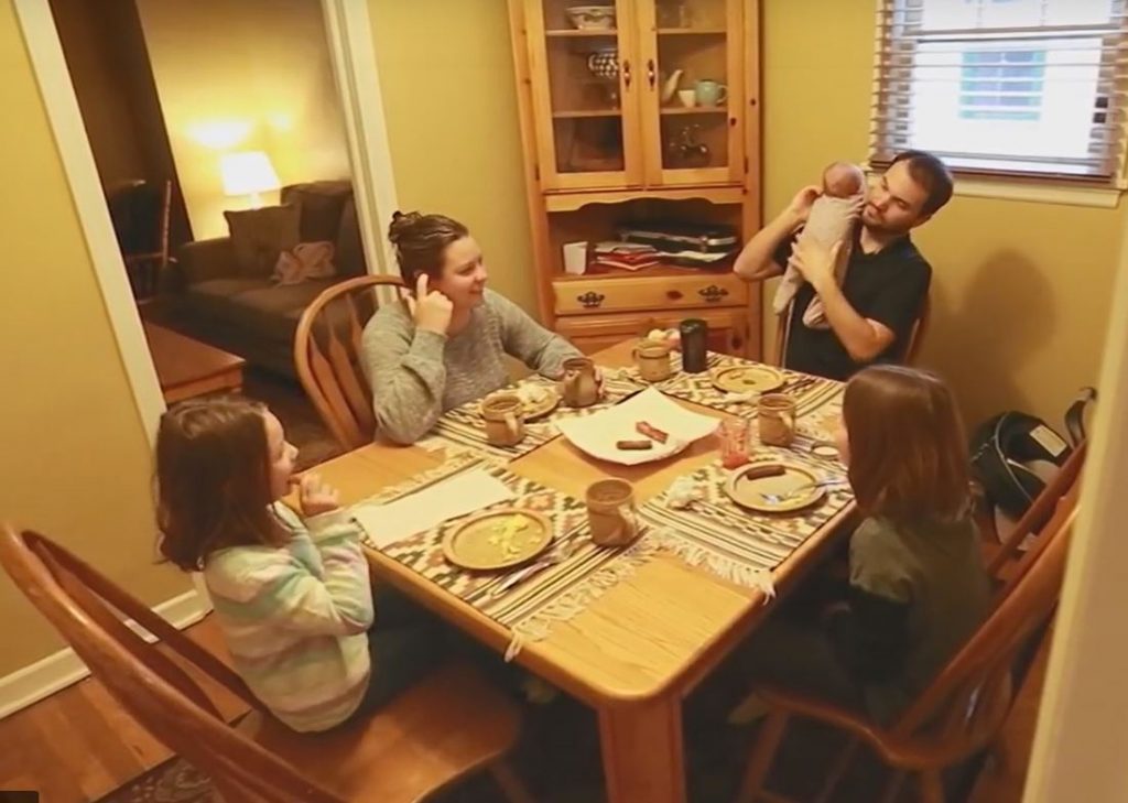 Makai Hall sits down to breakfast with his wife and three daughters.