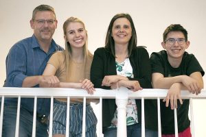family standing together leaning over banister.