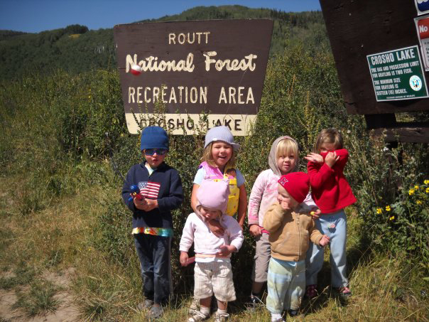Kid campers pose in front of a Forest Service sign near Steamboat