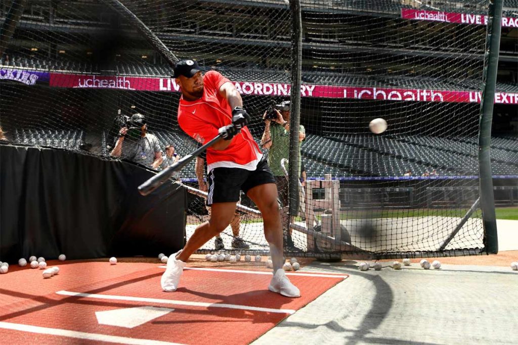 man swinging a bat at Coors Field