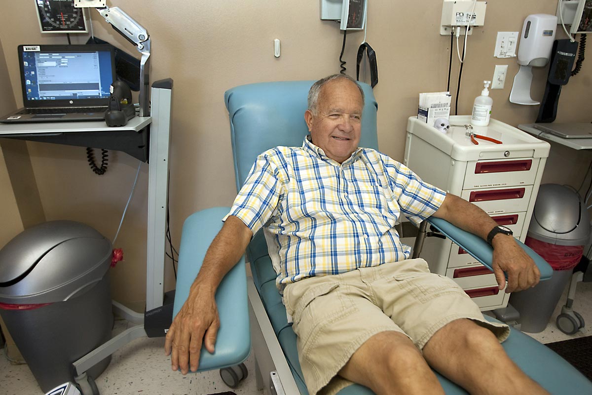 Simon sits in a blood donor chair.