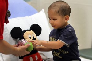 Boy reaches for a roll of medical tape