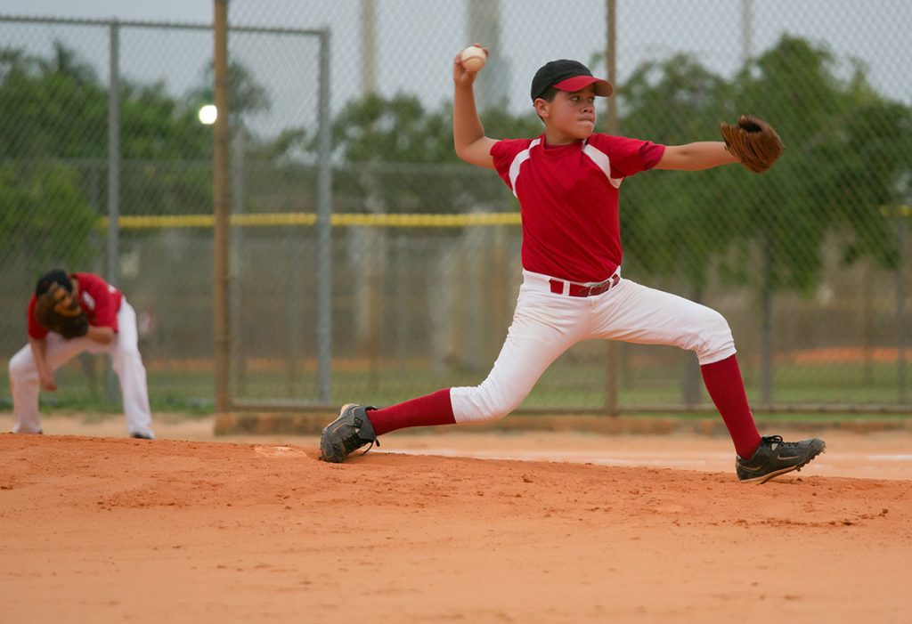 A young boy pitches a baseball during a game in this photo.