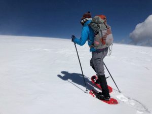women snowshoeing up a mountain