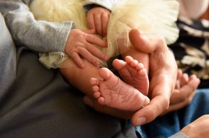 a baby's feet peak out of a gold tutu