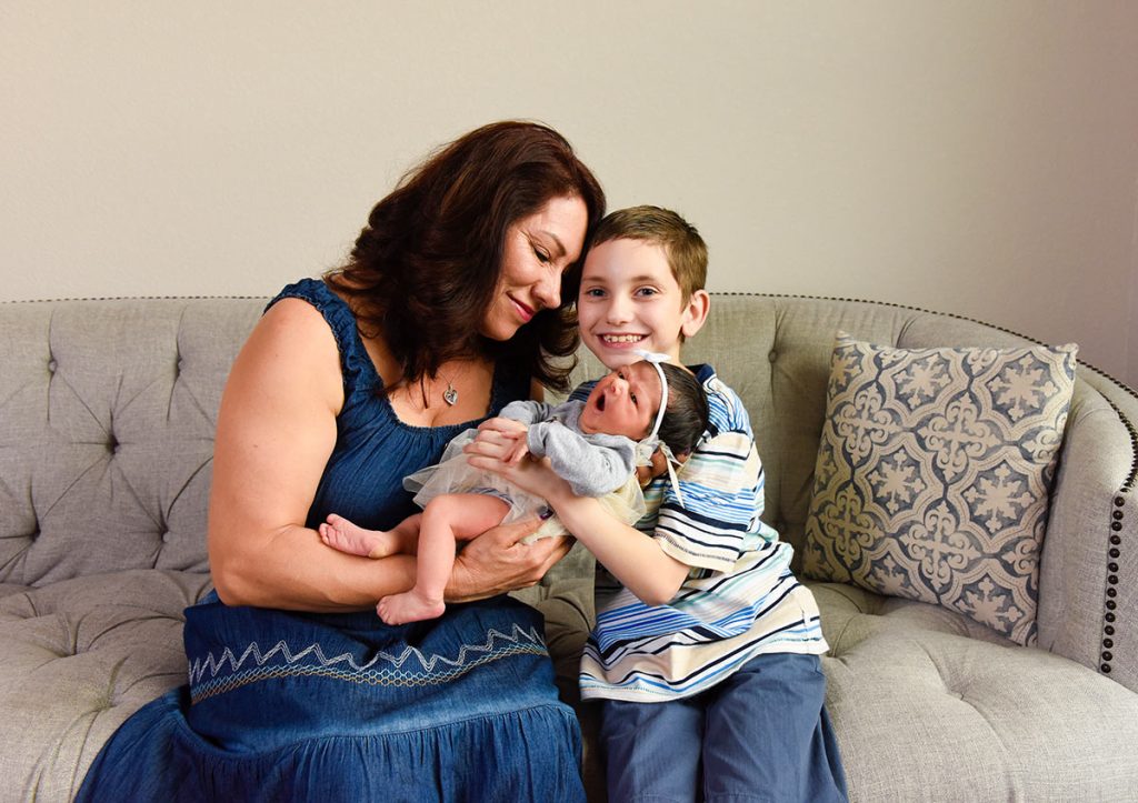 A young boy and his grandmother hold a 3-day-old baby in Greeley.