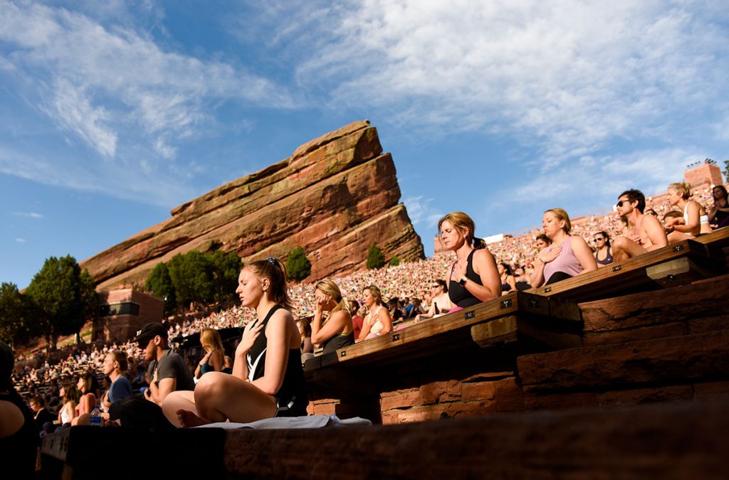People sit during a yoga class at Red Rocks Amphitheater.