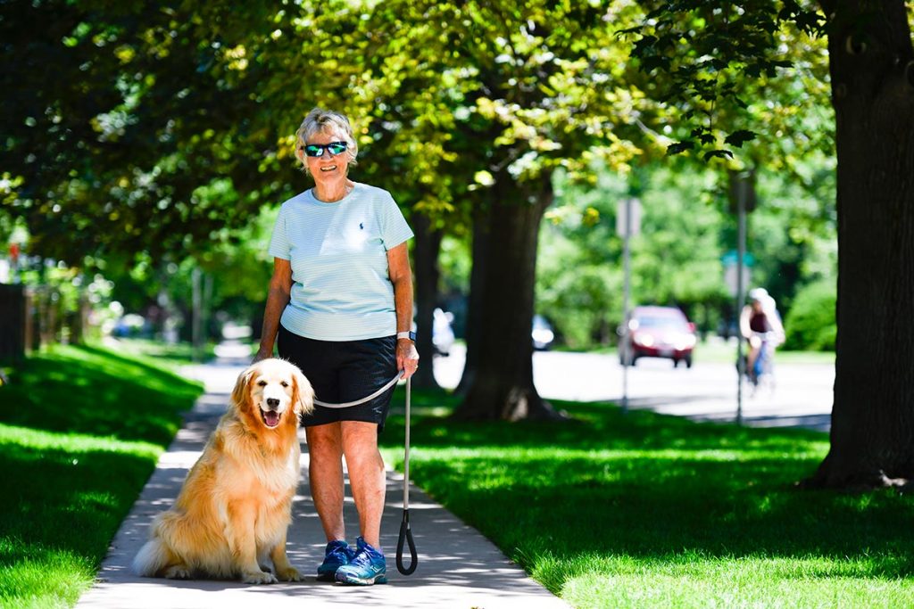 71-year-old athlete Susan High poses with her golden retriever