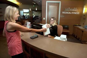 receptionist hands women a towel at the front desk