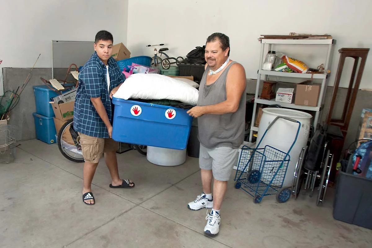 father and son work together to move camping gear into a truck, getting ready for a trip that was possible because John avoided risky surgery.