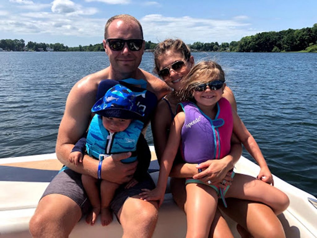 A photo of Emily Daniels, who is living with lung cancer, on a boat with her husband and children.
