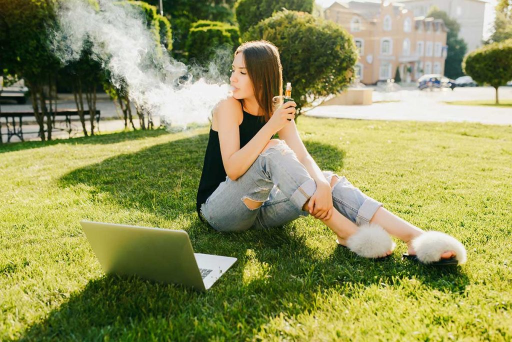 a photo of a young woman smoking an e-cigarette
