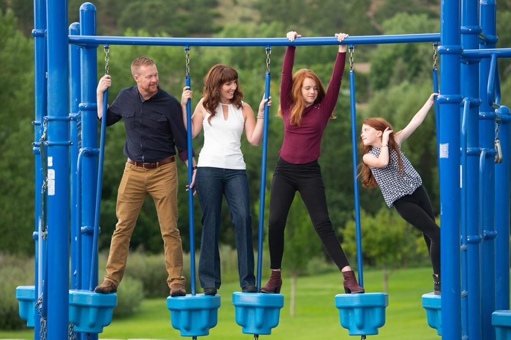 A photo of the Newbrough family on a set of swings