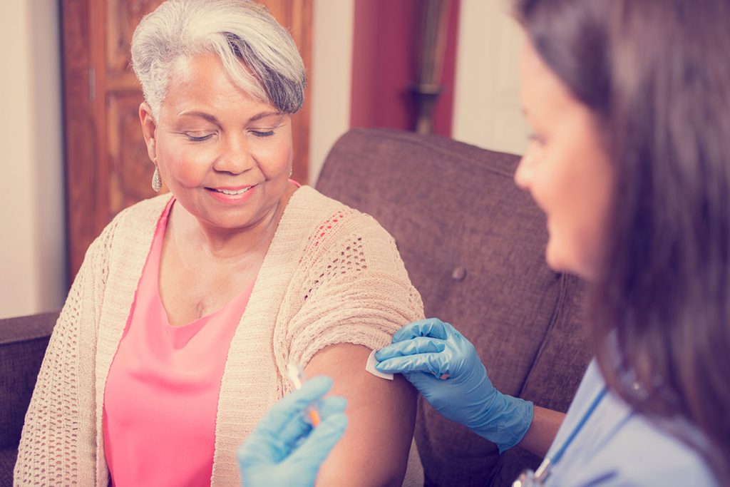 A woman gets a flu shot from a provider