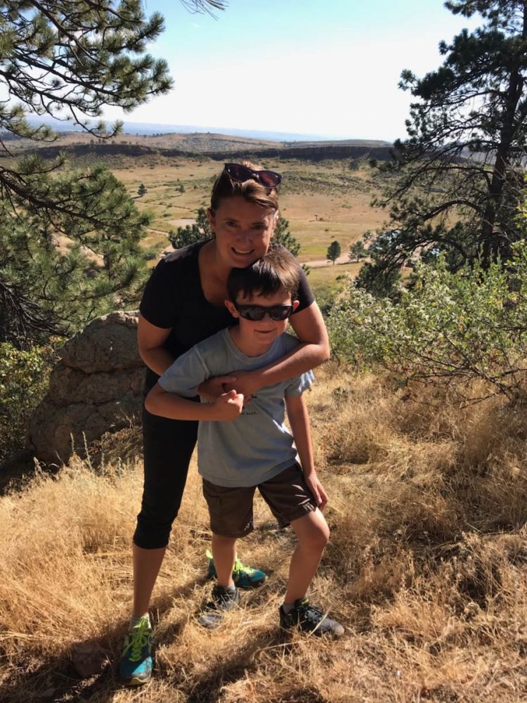 Kim with arms around son on top of a hill