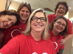 four women all in red team kim shirts