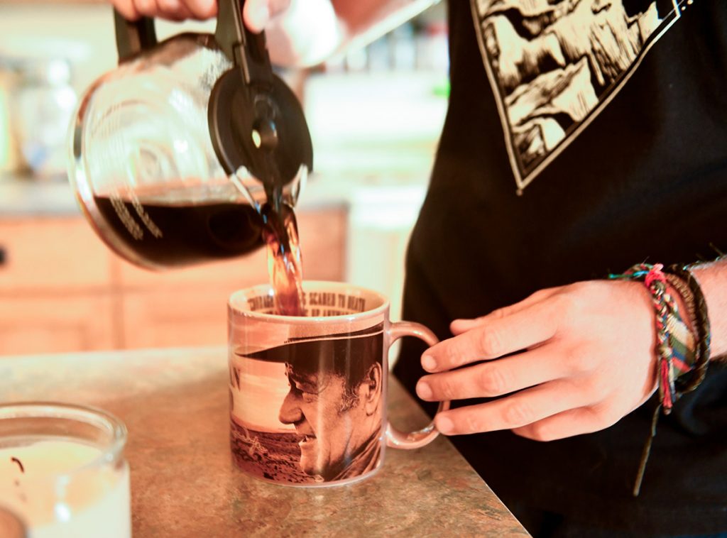 Nathan Kissack, a Wyoming rancher who had blood cancer, pours coffee into a John Wayne mug