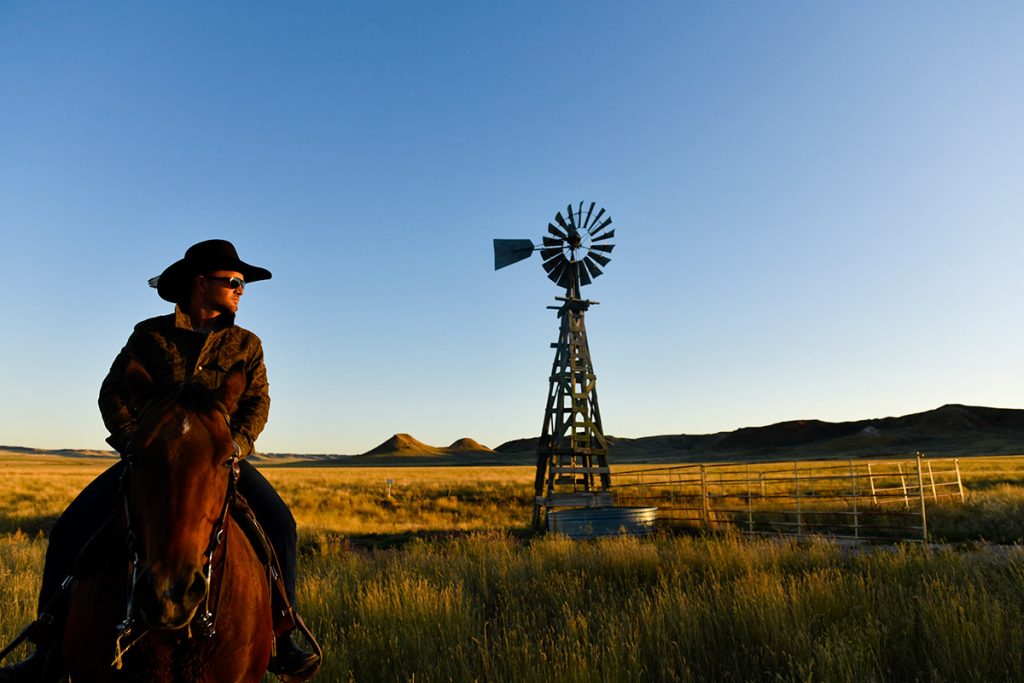 Nathan Kissack poses with an old fashioned windmill ner his family's ranch in Wyoming.