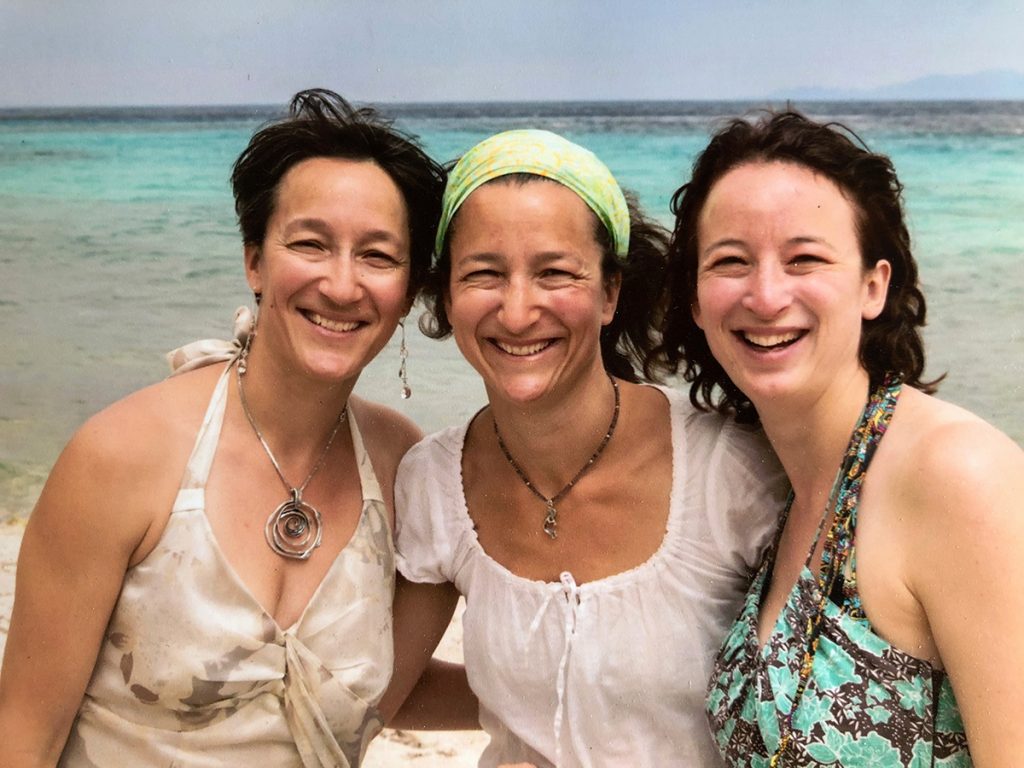 Sisters Alex Mathisen, Thea Pallut and Laura Gallagher pose for a photo on the beach in Greece in this photo.