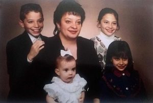 family photo of mom with her four young children, all of whom got prenatal care but the youngest through the Poudre valley prenatal care program.