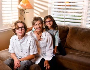 Women on couch with grandkids after healing from a hepatitis C-infected liver transplant, the first successful one done at UCH.