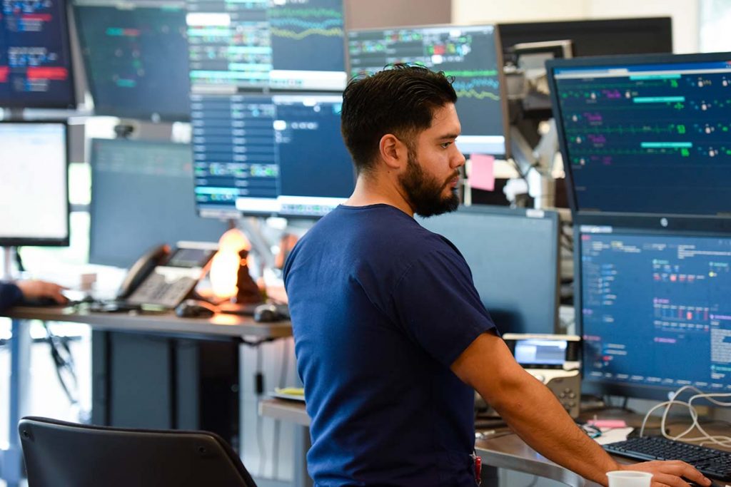 nurse looks at a bunch of computer screens with health information on them.