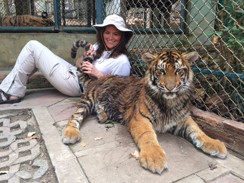 Marybeth Hoffman posing with a tiger during a trip to Thailand.