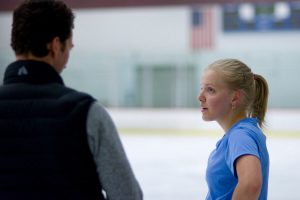 coach and skater talk at ice rink