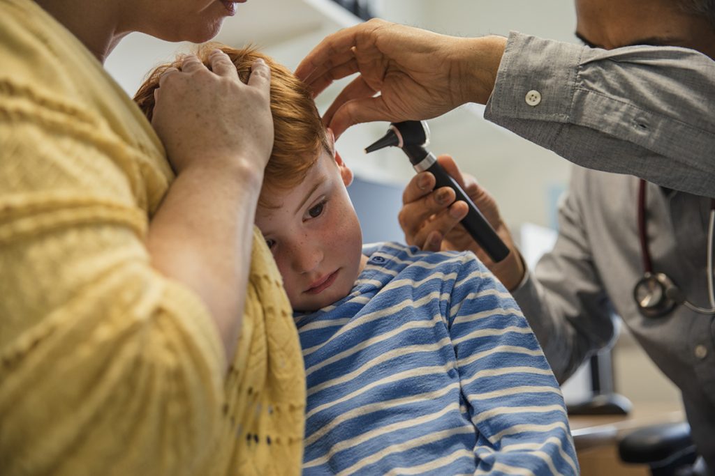 A young boy has his ear examined.