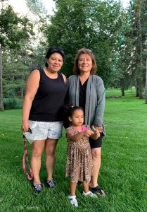 Three generations, mom, daughter and granddaughter, at a park.