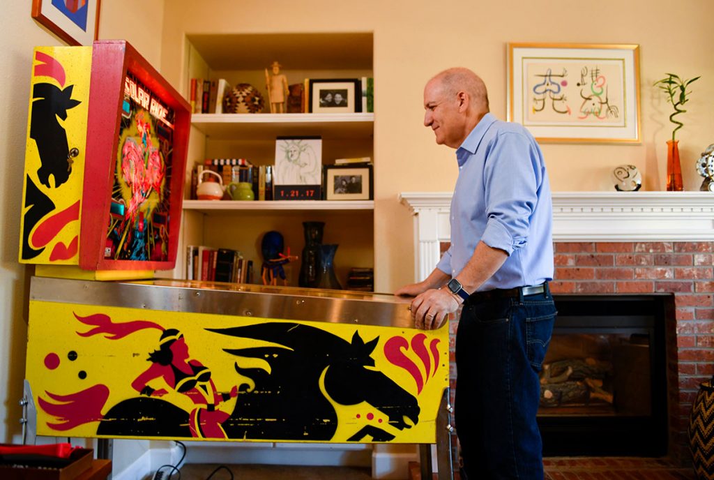 Jerry Oksner, who suffered a stroke in a hospital, plays pinball at home.
