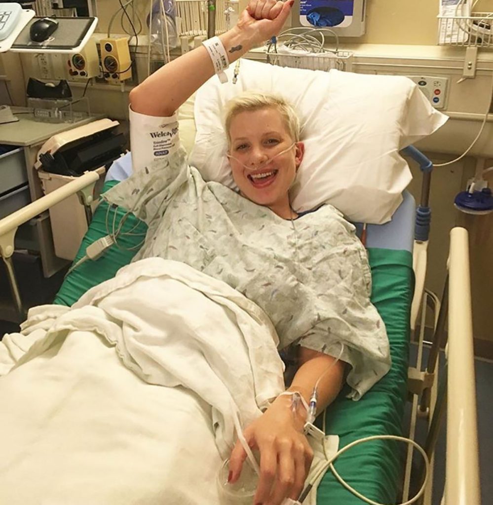 Even during the worst of her treatments, Lauren Race has smiled. Here she holds her arm up like she's victorious even though she's stuck in a hospital bed.