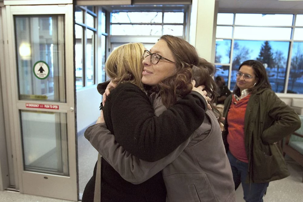 Patient's sister hugs her nurse inside the hospital.