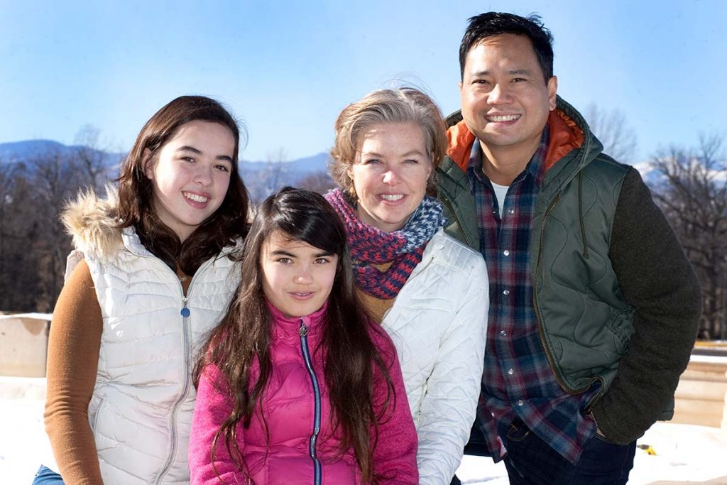 family of four photo together at a park.