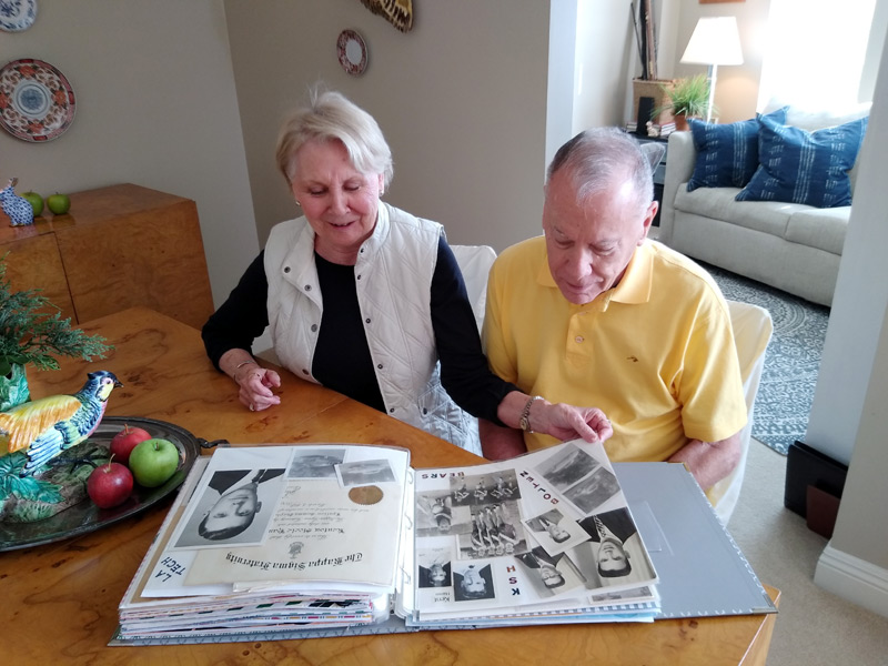 couple looks at a scrap book that helps the husband, who is living with dementia, remember things.