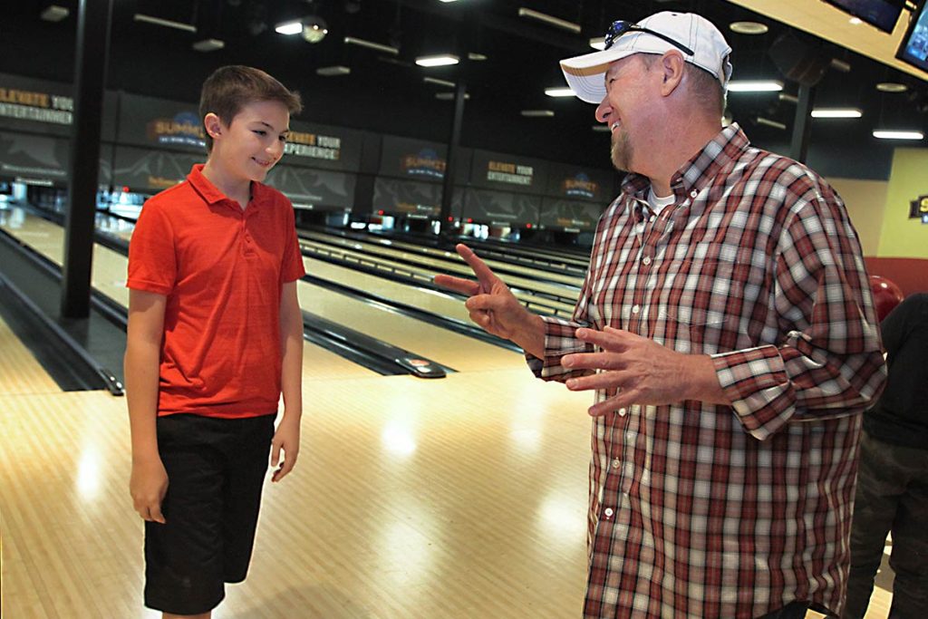 Keith talks with his son at the bowling alley.