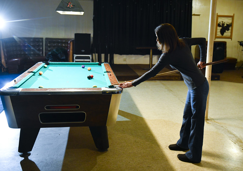 woman gets ready to take pool table shot.