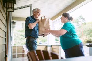 women hands older adult a bag of food.