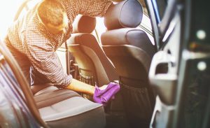 man disinfecting coronavirus in his car