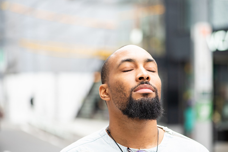 man breathing with eyes closed, a way to tame fight-or-flight to coronavirus.
