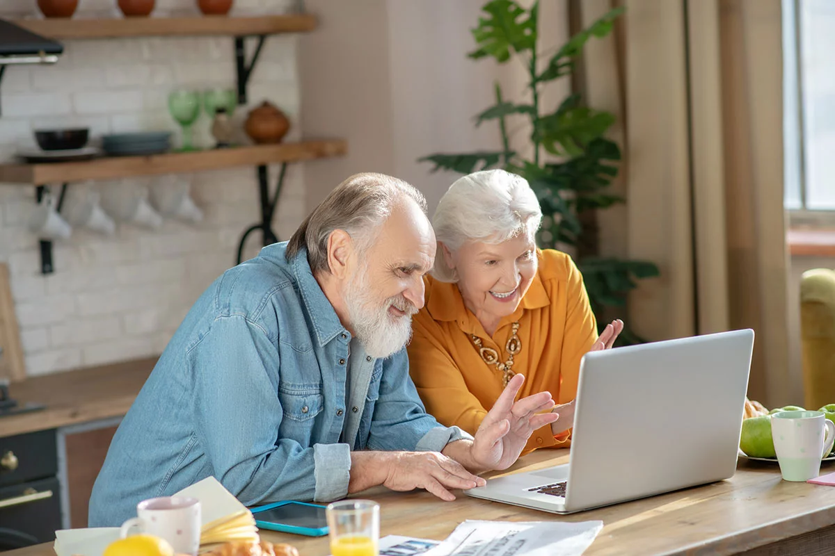 an older couple does a video chat on a computer