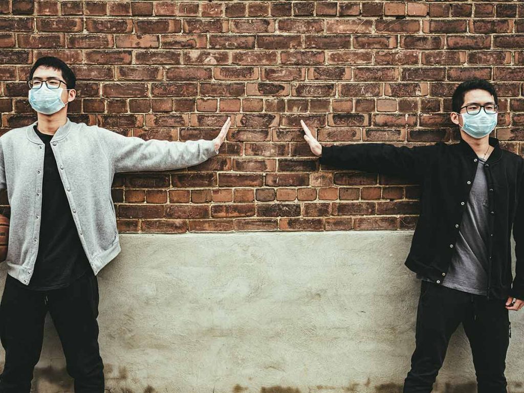 Two young men demonstrate social distancing, a practice that the 'return to normal' models demonstrate is working in colorado