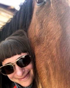 women with her horse, happy after she was able to solve her problems with a Virtual Visit with a gastroenterologist