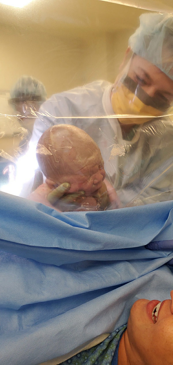 Giving birth in a pandemic. Dr. Hoss holds up Deacon to meet his mom for the first time.
