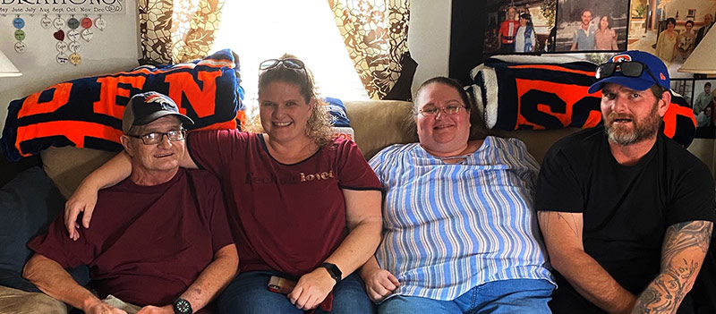 four family members sit on the couch for a photo, which was their christmas card in 2019 after one of them went from a LVAD to a heart transplant.