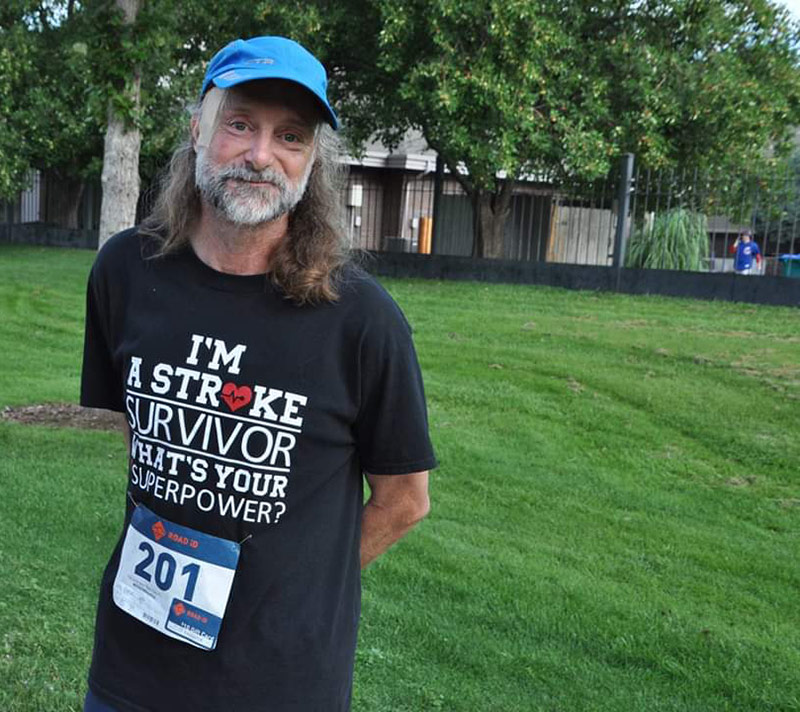 Jeff with a t-shirt that says I'm a stroke survivor, what's your superpower. Jeff received hemorrhagic stroke treatment at UCHealth Medical Center of the Rockies.