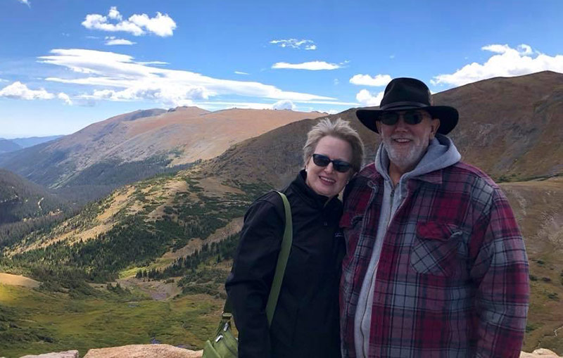 Jim, who had nonalcoholic fatty liver disease, with his wife with the mountains behind them.