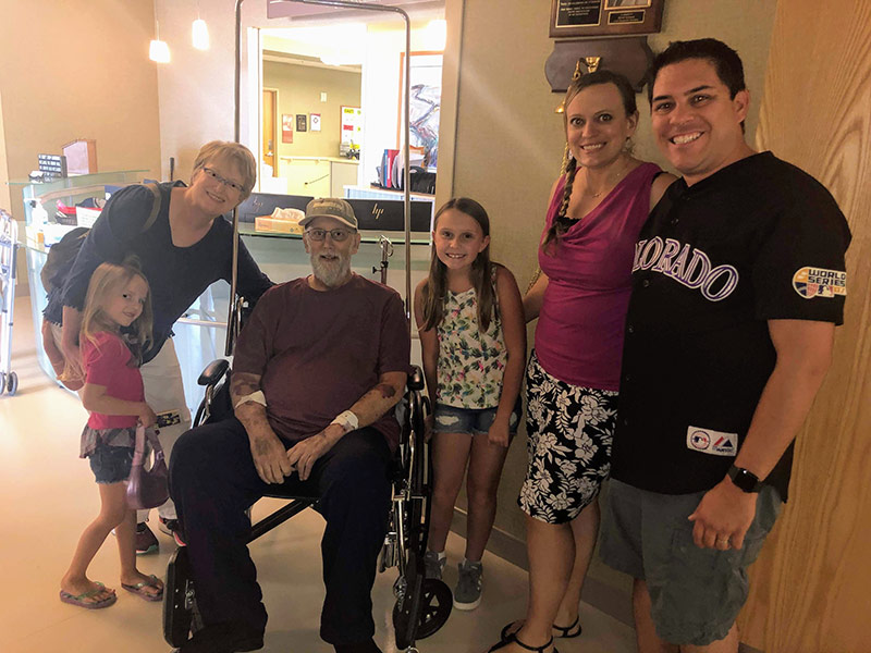 Jim in a wheelchair after treatment for nonalcoholic fatty liver disease with his family by his side.