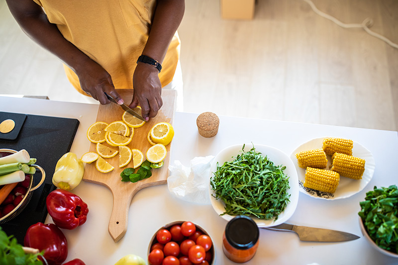 cutting lemons, with other vegetables on the table, as part of flavor pairing.